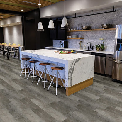 Wilmont Woodrift Gray glue down luxury vinyl flooring shown in a furnished room