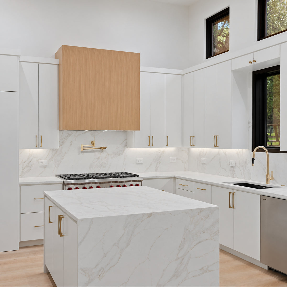 Regal Arabescato Gold Matte silica free quartz countertop by Stratus Surfaces in a finished kitchen, matte finish on the island and backsplash with white stone and soft gold and grey veining
