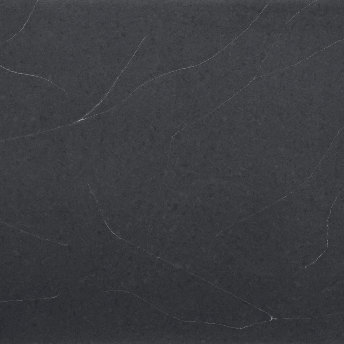 Regal Soapstone silica free quartz slab sample by Stratus Surfaces, deep charcoal black with white and gray veining, polished finish, close up